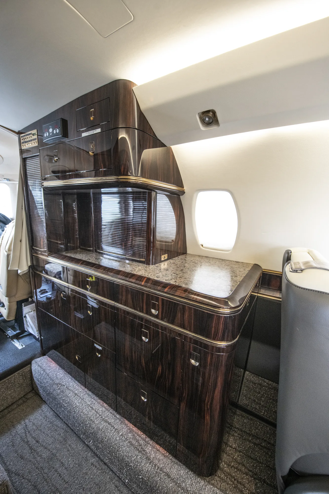 Citation X forward galley with stone counter and ebony cabinetry